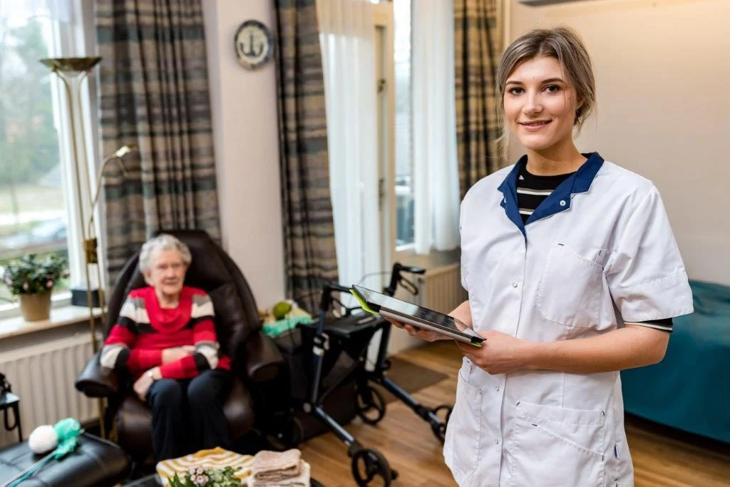 Gezellige woonkamer van Maanderzand met comfortabele stoelen, houten tafel en grote ramen met uitzicht op groen
