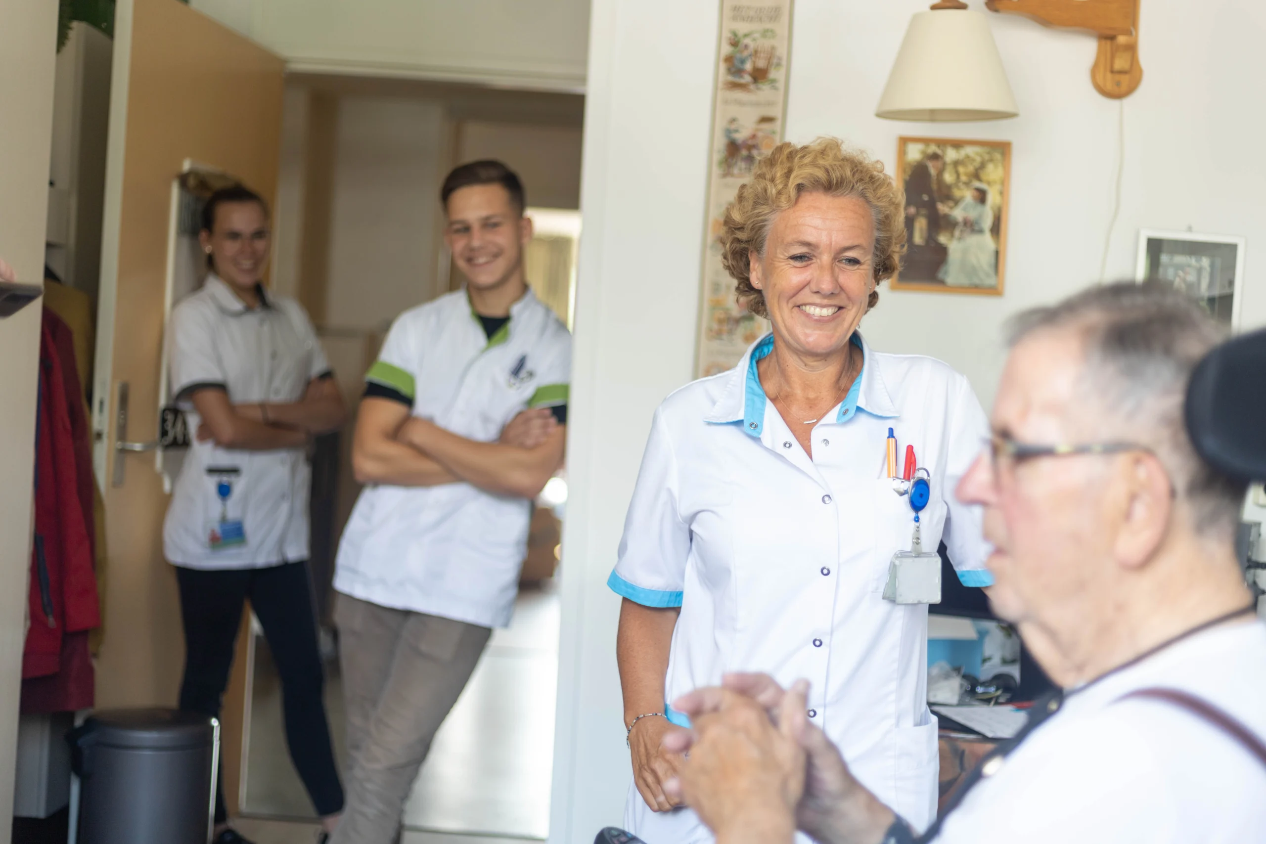 Gezellige woonkamer in Maanderzand met ouderen die samen een bordspel spelen aan een houten tafel